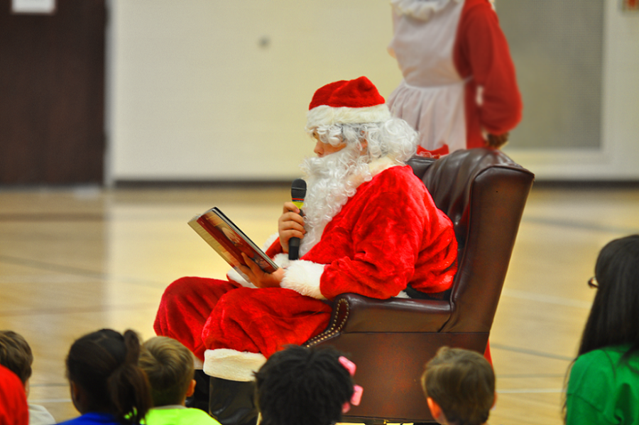 A+crowd+of+children+watch+as+some+of+their+friends+are+chosen+to+sit+at+Santas+feet