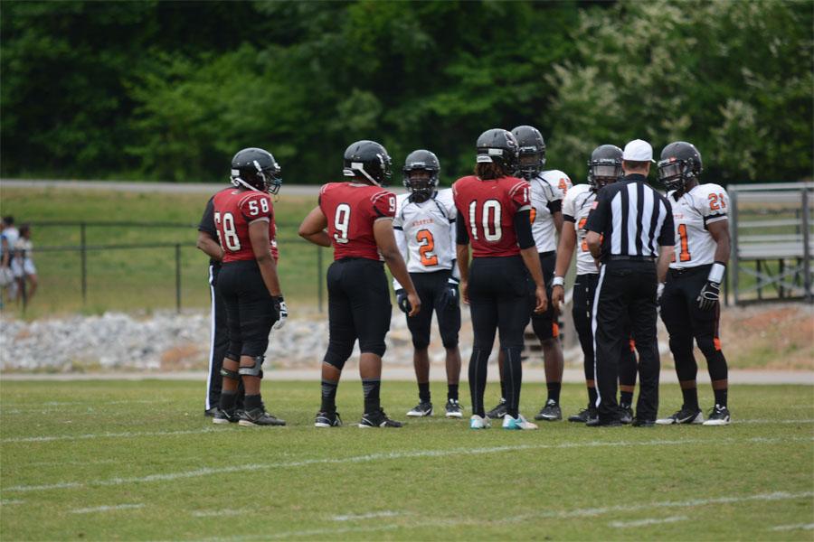 The team captains meet out on the field. 