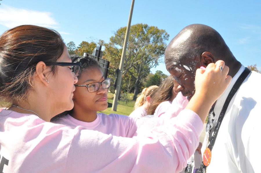 Assistant principal Maurice Jones get assistance in putting on his googles for the pie in the face event. Students paid $1 to throw the pie. 