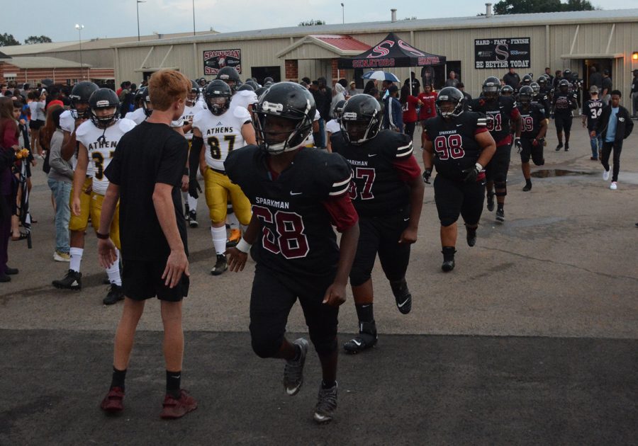 The football team takes the field after lightening delay. They defeated Athens 35-10 in the jamboree game.