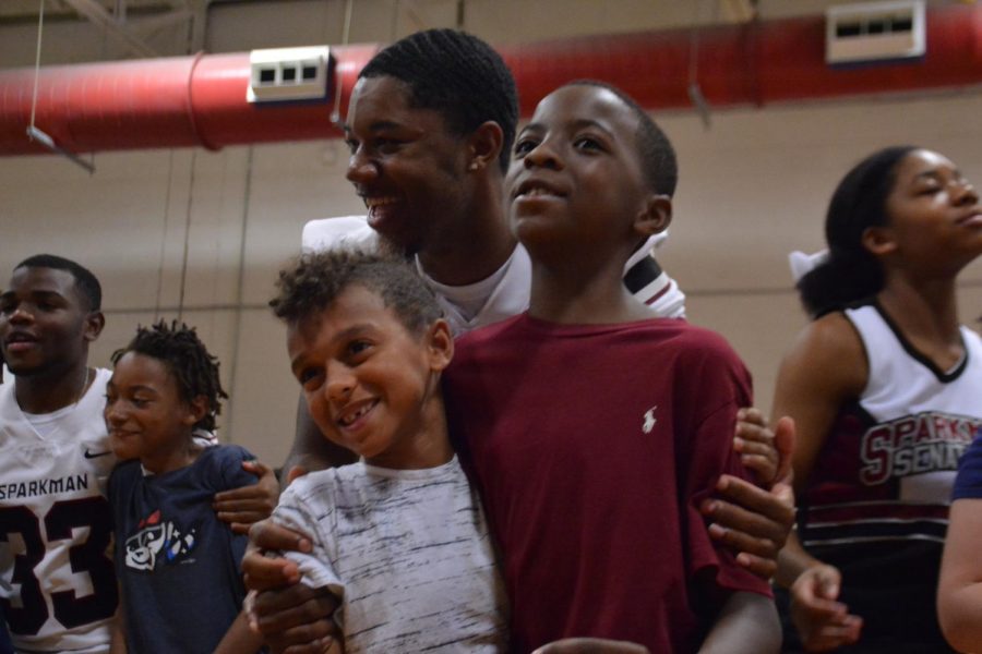 Senior Dallas Baker embraces two young students at Endeavor Elementary, urging them to get into the Senator spirit. 