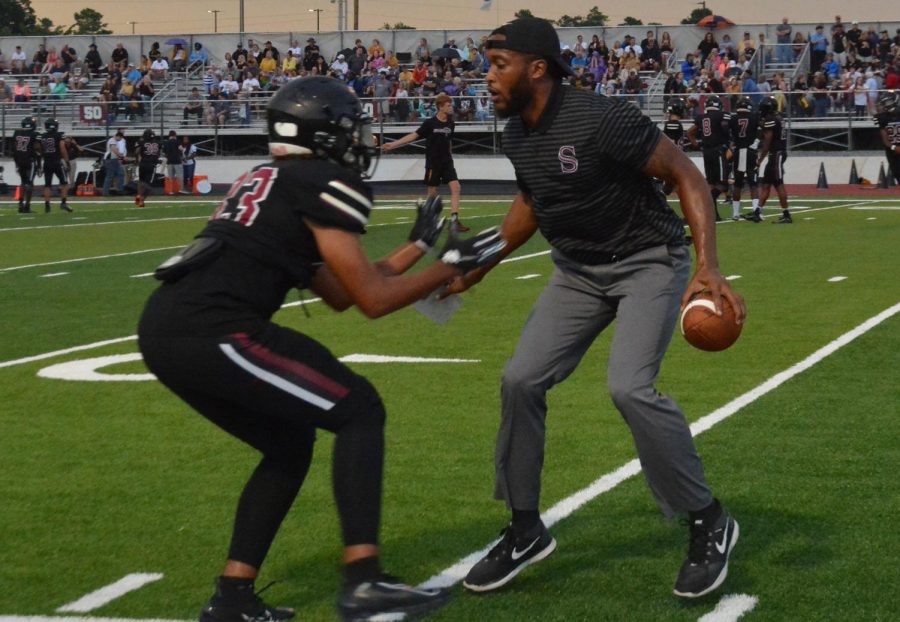 Senior Dallas Baker gets hyped with coach Darwin Salaam during warm-ups. 