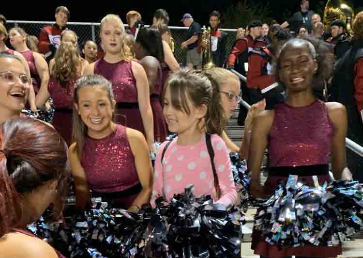 Sitting with the color guard at the James Clemens football game, 7-year-old Arabella Zapp enjoys her night. 