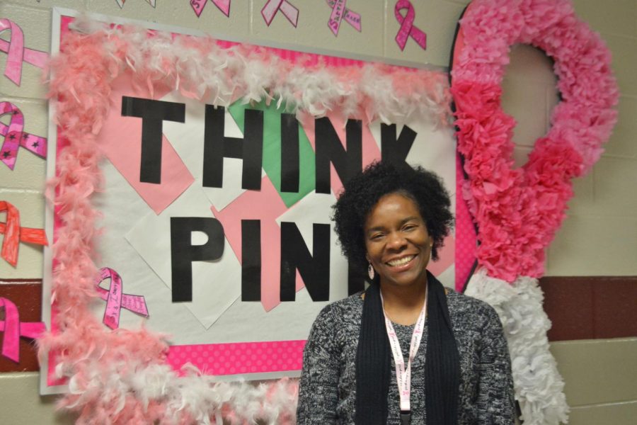 Aide Stacy Gilbert poses in front of the bulletin board created in the Sparkman Learning Community wing. Gilbert has received treatment for breast cancer three times. 