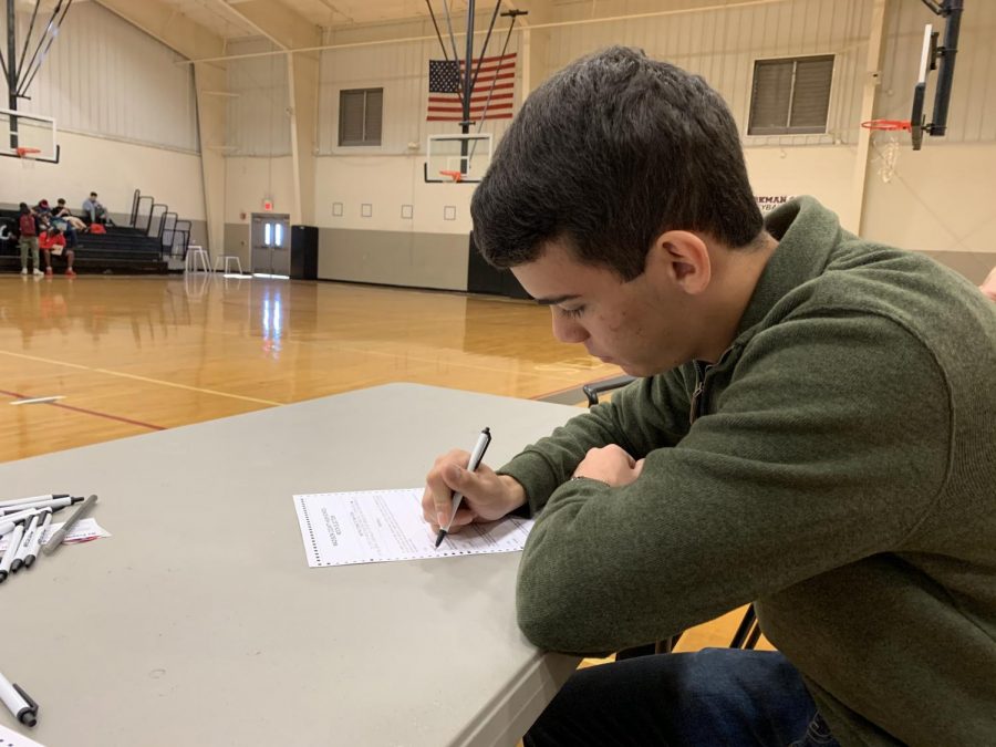 Marking his ballot, senior Michael Bodeker casts his vote. 