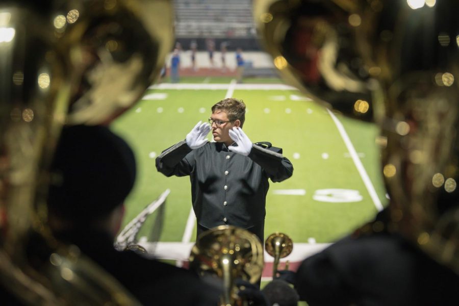 Leading the marching band at the game against Decatur, sophomore Kaden Burgess gets his first taste of directing music. 