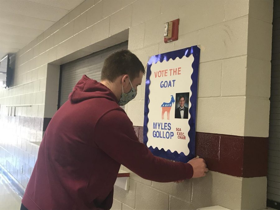 Senior Myles Gollop hangs up various campaign posters around the school. Gollop has spent a lot of time devoted to campaigning and reaching out to students.