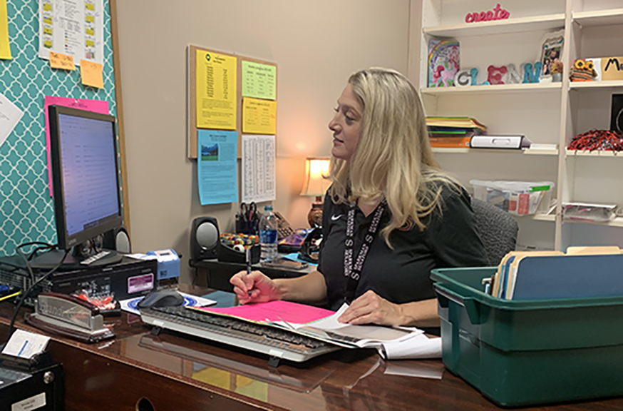 Working on scheduling, Co-Op teacher Brandi Glenn updates students progress. 