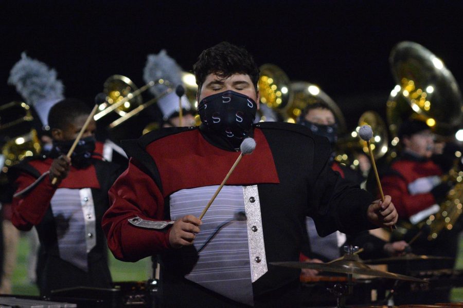 In the middle of the performance, senior Dylan Lancaster plays his instrument. The band performed their competition show at the last home football game of the year. 