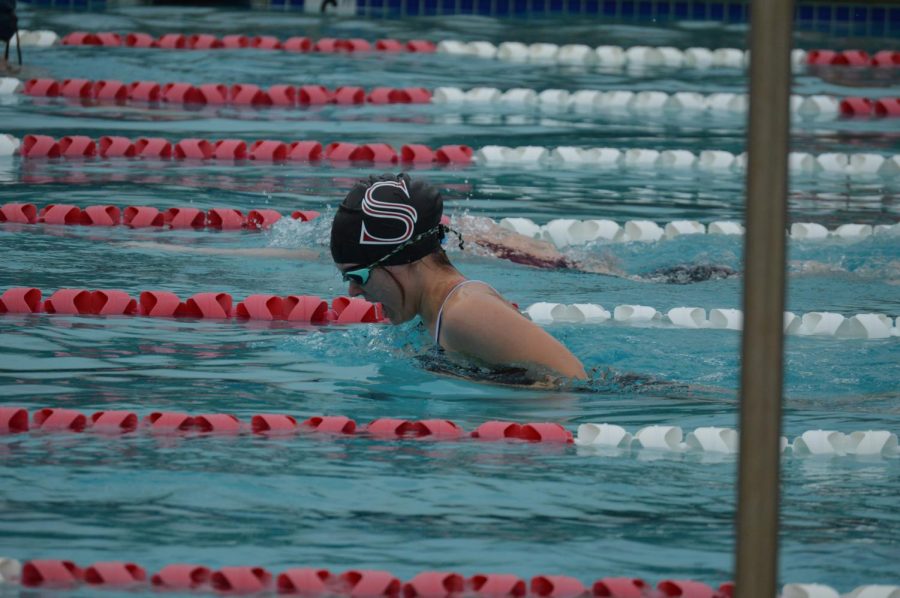 Competing+in+the+breast+stroke%2C+senior+Emily+Hammer+rises+to+take+a+breath.+