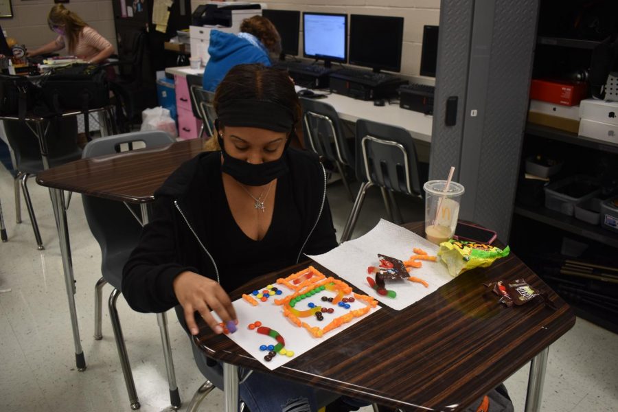 Yearbook co-editor Janiyah Blue uses food to work on design patterns. 