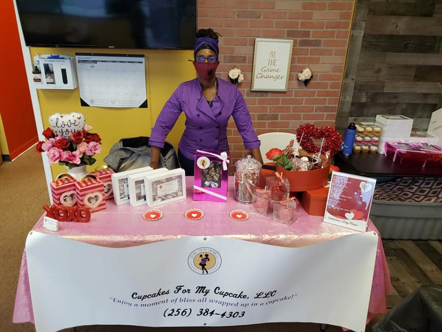 A representative from Cupcake for my Cupcake shows off a display of baked goods. The business is just one of many black-owned businesses thriving in the community.