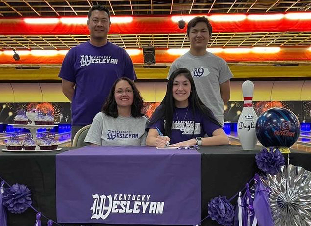 Senior Daylin Tolgo signs bowling scholarship with her family present. She held her signing at the Madison Bowling alley. 