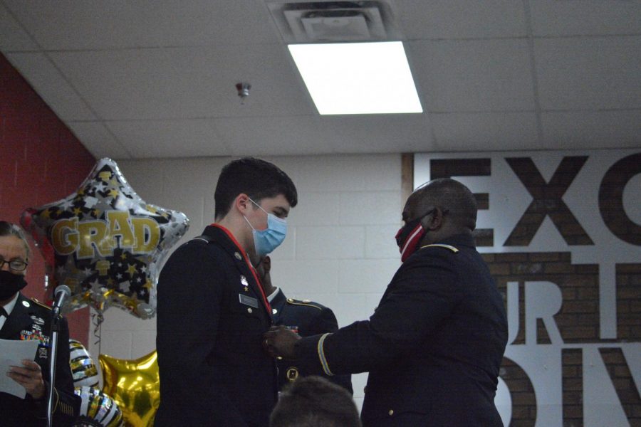 Senior Logan Barley receives his JRTOC award from Lt. Col. Nathan Lloyd at the annual JROTC senior night. Barley was accepted into West Point. 