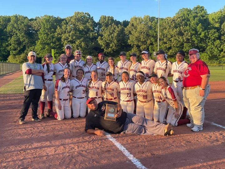 Coach Dale Palmer lays it down for his team in a photograph, capturing their area title trophy. 