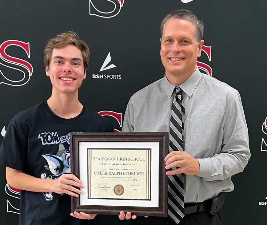 Senior Caleb Etheride poses for a publicity photo with principal, Chris Shaw.
