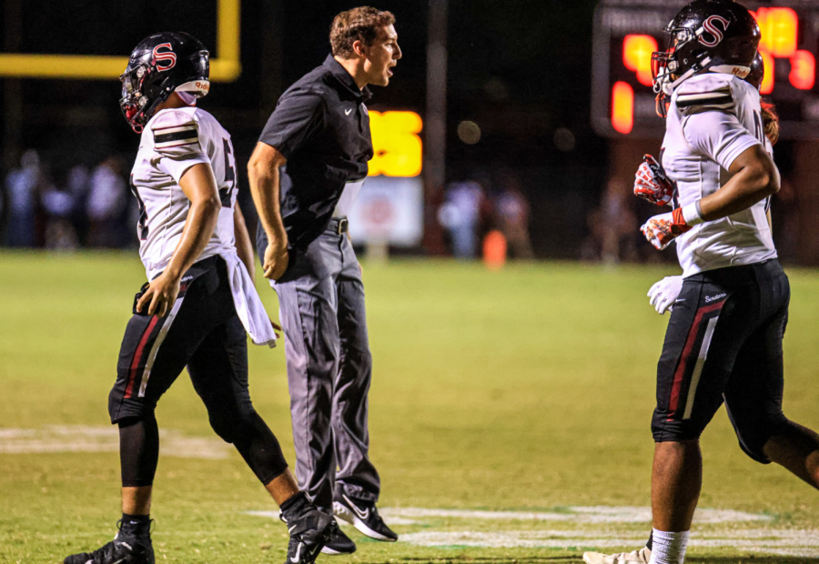 New offensive coordinator Spencer Smith jumps with excitement as he greets football player Briace  McBeth. 