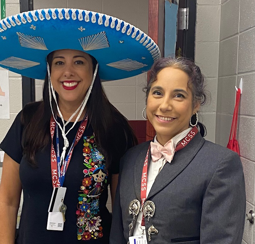 Teachers%2C+Carla+Naves+Pena+and+Kyra+Espinosa%2C+pose+for+a+quick+camera.+The+two+dressed+up+to+show+their+Hispanic+heritage.+