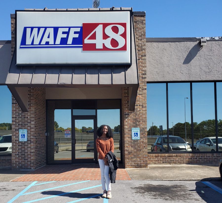 Senior Kyla Davidson stands proudly under the WAFF-48 sign at the stations location on Memorial Parkway. 