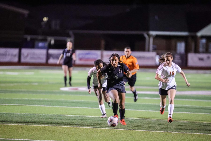 Taking the ball up the field in last years game against Austin, junior Jayda Davis gets the ball closer to the goal. 