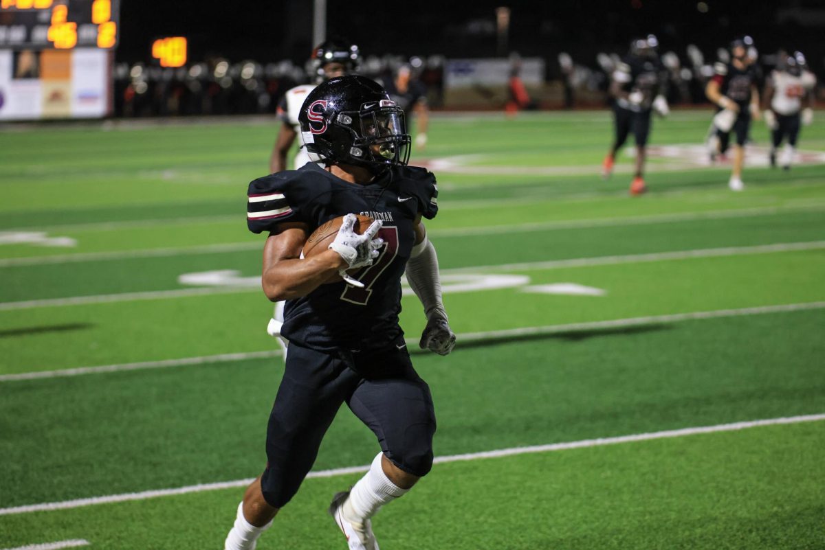 Jayden Thomas clutches the ball as he runs towards the teams end zone.