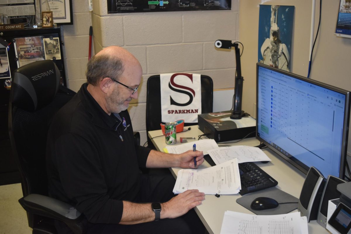 Grading papers, science teacher Scott Coonfare utilizes his planning period. Coonfare left a job in the restaurant industry go become a teacher. 