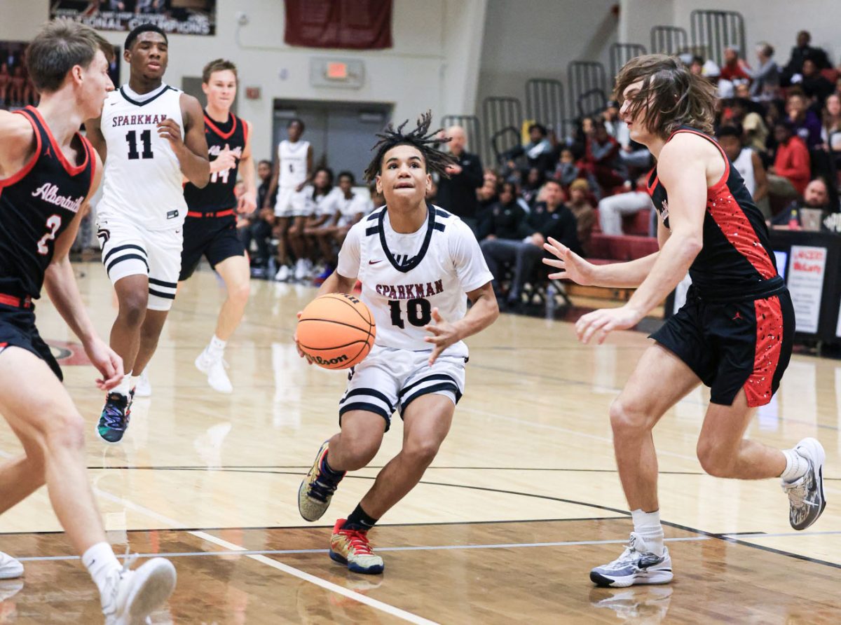 Threading Albertville defenders, eighth grader Ty Pace drives to the basket. Pace, moved up from the freshmen team earlier in the season, has led the Senators in points in several games this season. 