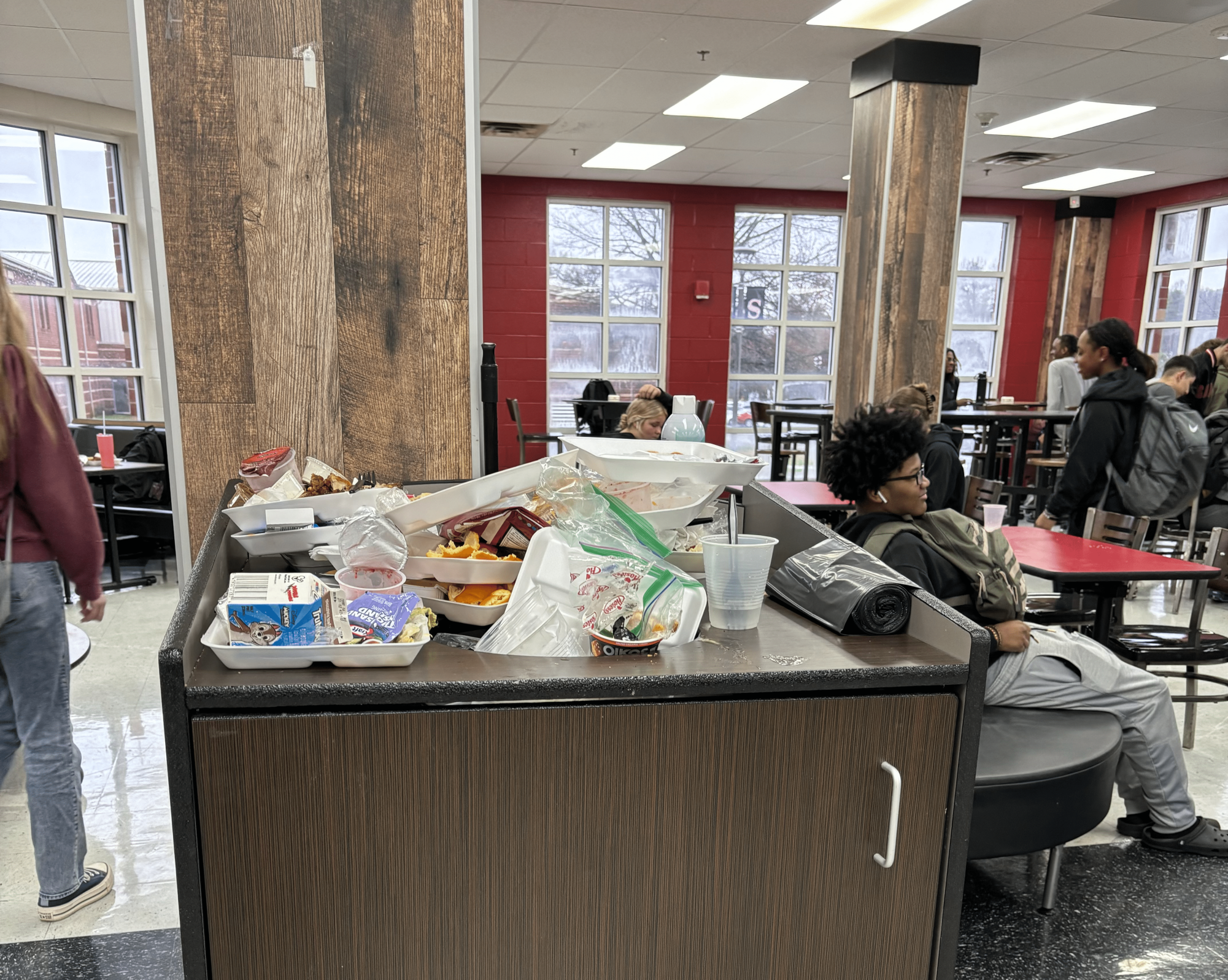 This photo shows the build-up of trash in cafeteria from students not utilizing the other trash cans, creating more mess for the custodians to clean. 